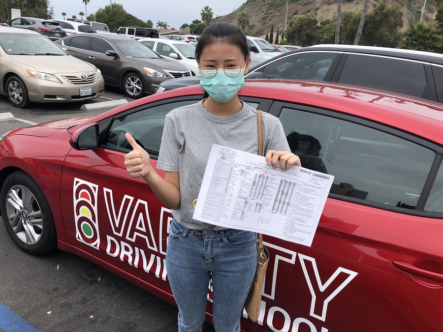 Huntington Beach Driving School Female Student Standing Next to a Training Vehicle