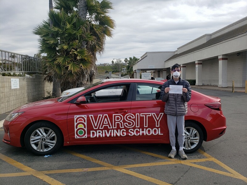 Laguna Beach Driving School Male Student Standing Next to a Training Vehicle