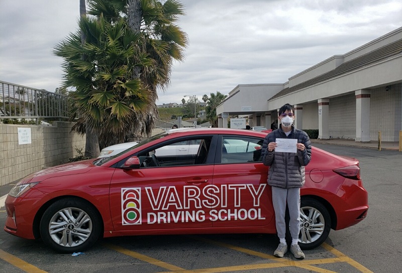 Orange County Driving School Male Student Standing Next to a Training Vehicle