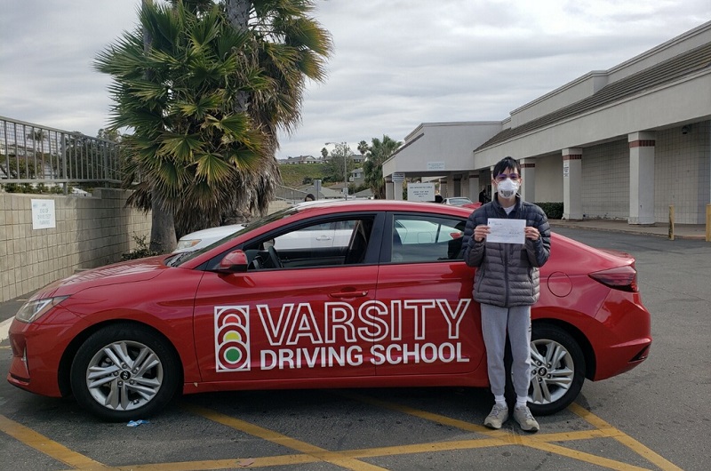 Costa Mesa Driving School Male Student Standing Next to a Training Vehicle