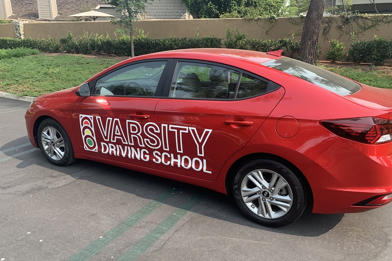 Best Driving Lessons in Laguna Beach Red Training Vehicle in a Parking Lot