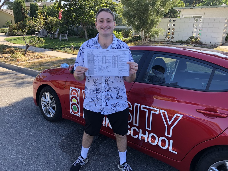 Irvine Driving School Student Standing Next to Red Training Vehicle