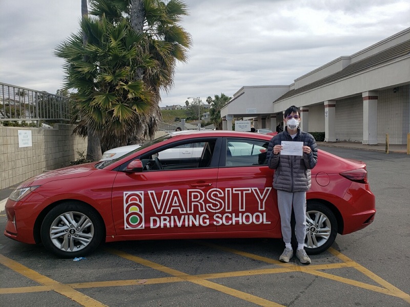 Driving Lessons in Santa Ana Student Standing Next to a Training Vehicle