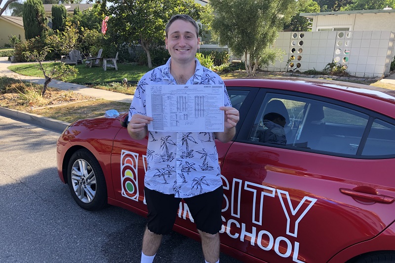 Driving Lessons in Costa Mesa Male Student Standing Next to a Training Vehicle