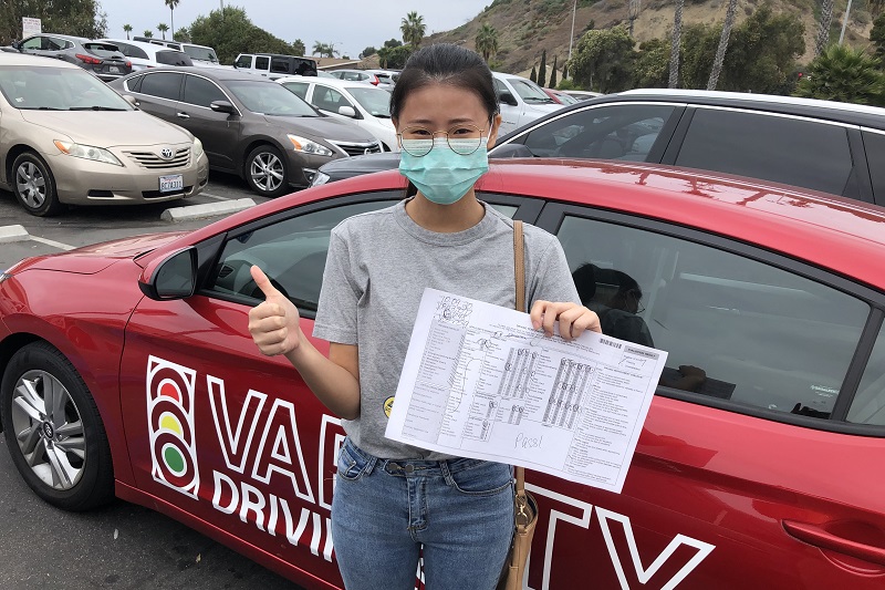 Irvine Behind the Wheel Training Woman Standing Next to a Training Vehicle