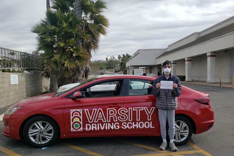 Irvine High School Driving School Male Student Standing Next to a Training Vehicle