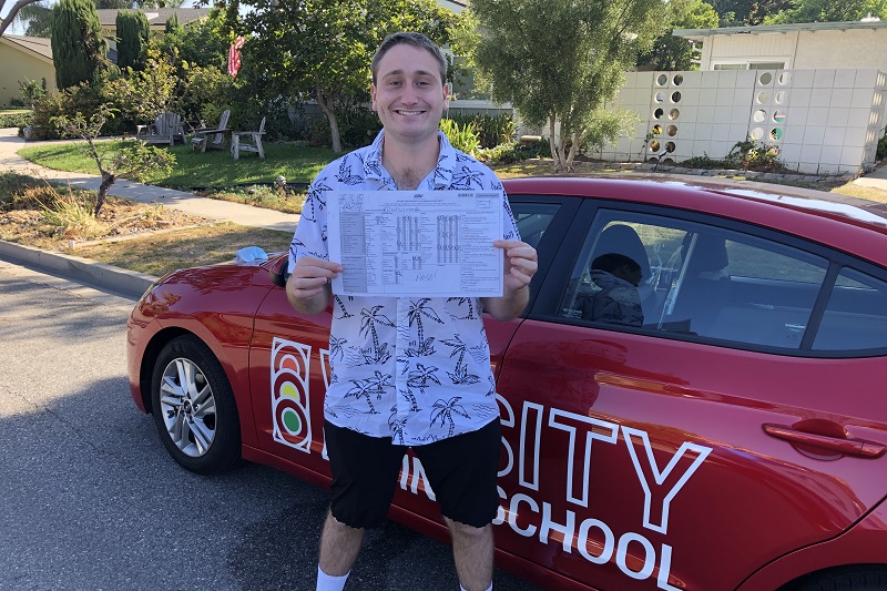 Foothill High School Driving School Male Student Standing Next to a Training Vehicle