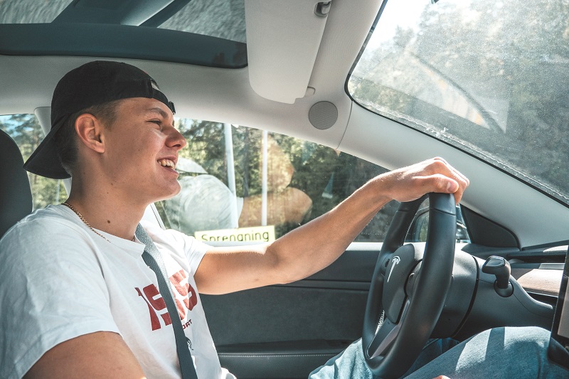 Irvine DMV Drivers Ed Test Prep Tips Teen Sitting in a Driver Seat Smiling