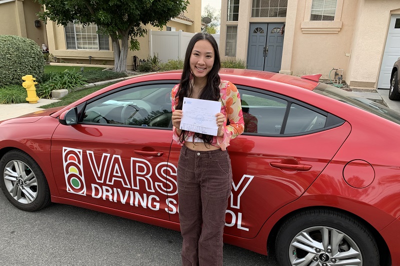 Huntington Beach High School Driving School Female Student Standing Next to a Training Vehicle