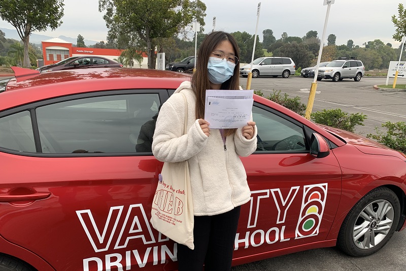 Marina High School Drivers Ed and Driving School Female Student Standing Next to a Training Vehicle