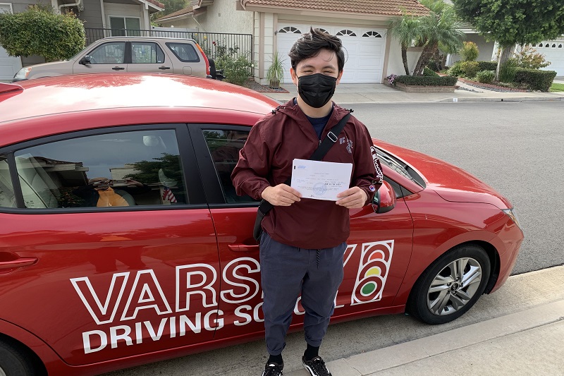 Fountain Valley High School Driving School Male Student Standing Next to a Training Vehicle