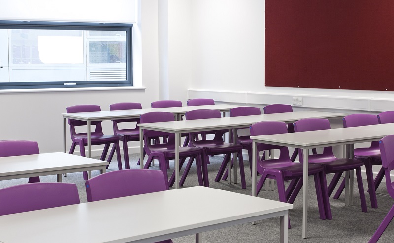 Huntington Beach High School Reviews Empty Classroom with White Desks and Purple Chairs