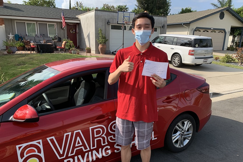 Western High School Driving School Student Standing Next to a Training Vehicle