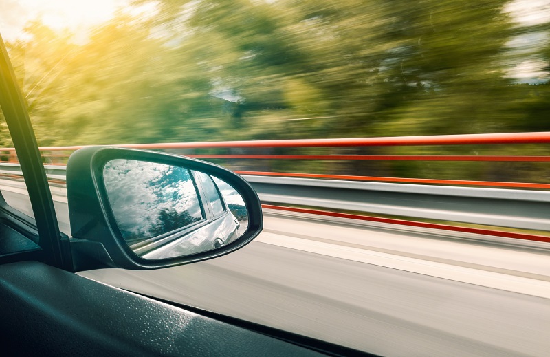 Where to Practice Driving in Santa Ana Close Up of a Side View Mirror from Inside the Car as it Drives Down the Highway