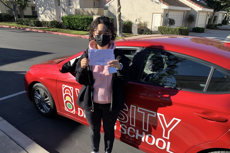 Granite Mountain Charter School Driving School Student Standing next to a Training Vehicle After Passing the Driving Test