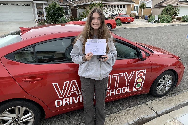 Best Estancia High School Driving School Student Standing Next to a Training Vehicle Outside Her Home