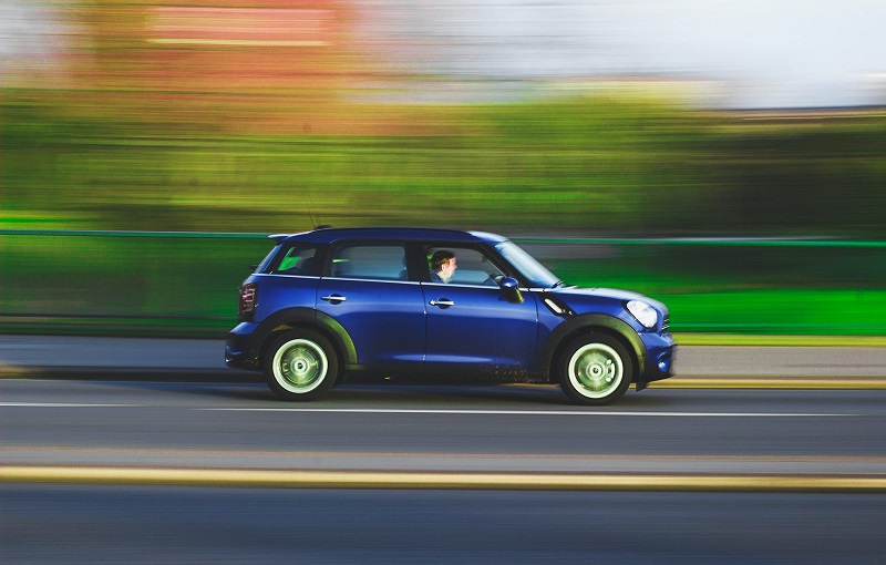 How Long does Driving School Last in California  A Blue Car Driving Down a Highway with the Background Motion Blurred 