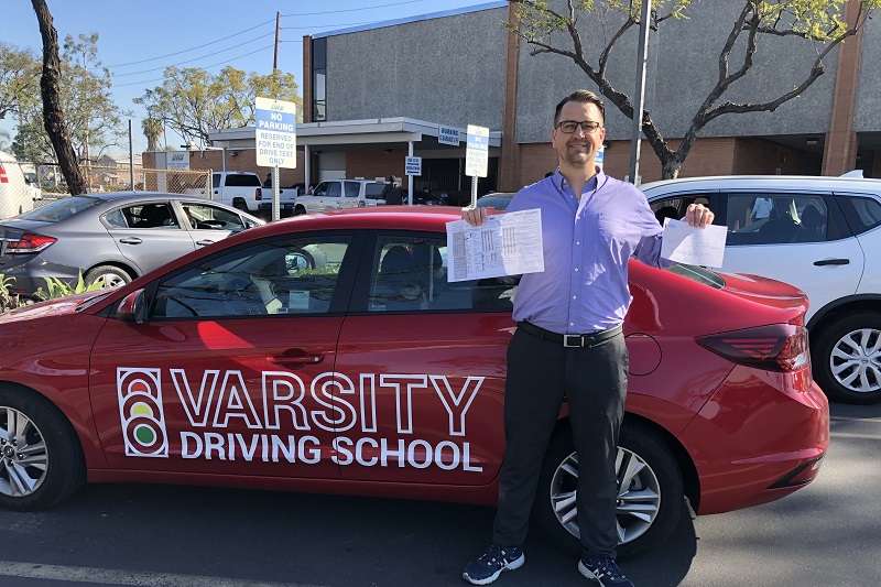 Where does Varsity Driving School Drive to in Orange County for Parents Adult Student Standing Next to a Training Vehicle