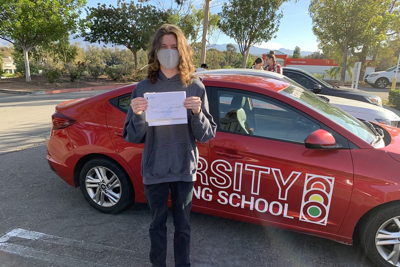 Hillview High School Driving School Male Student Standing Next to a Training Vehicle