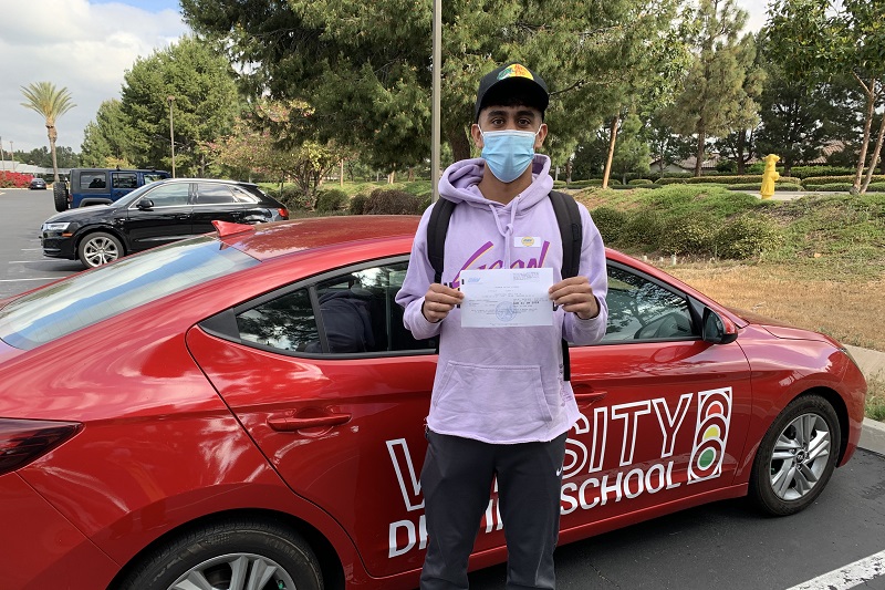 Best Capistrano Valley High School Driving School Male Student Standing Next to a Training Vehicle in a Parking Lot