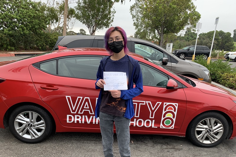 Best Dana Hills High School Driving School Student Standing Next to a Training Vehicle in a Parking Lot