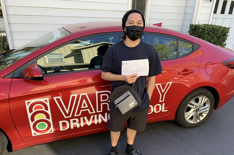 Dana Hills High School Drivers Ed Student Standing Next to a Training Vehicle in a Driveway