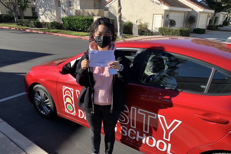 Best Canyon High School Driving School Student Standing Next to a Training Vehicle Parked Along a Curb