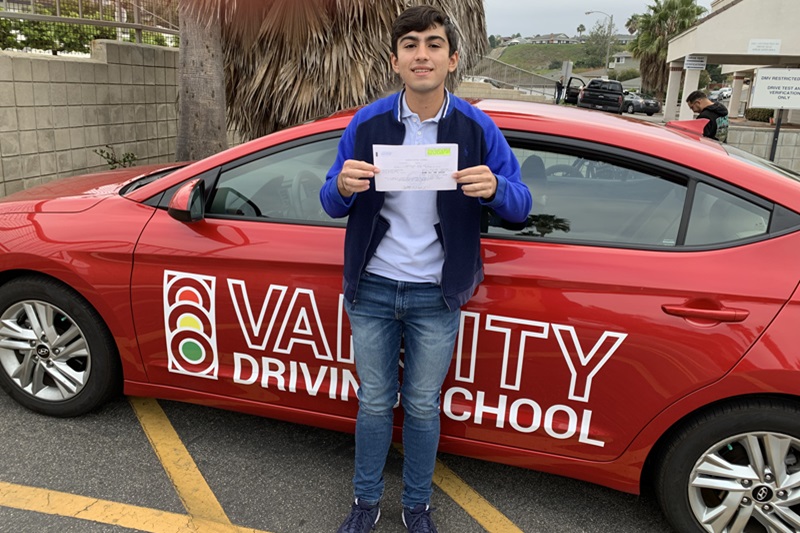 Best Savanna High School Driving School a Student Standing Next to a Training Vehicle Holding Up a Passed Driving Test Form