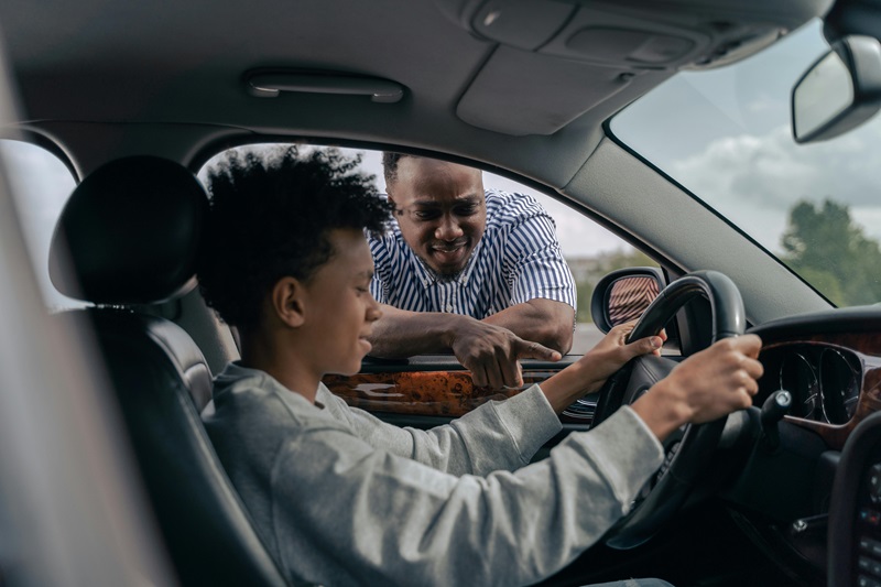 Best Santa Rosa Academy Driving School a Teen in the Driver Seat of a Car with a Father Looking in Through the Driver Side Window