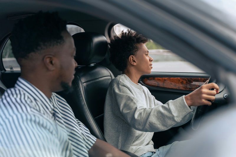 Best Middle College High School Driving School Father and Son in a Car with the Son in the Driver Seat and the Father Watching Closely