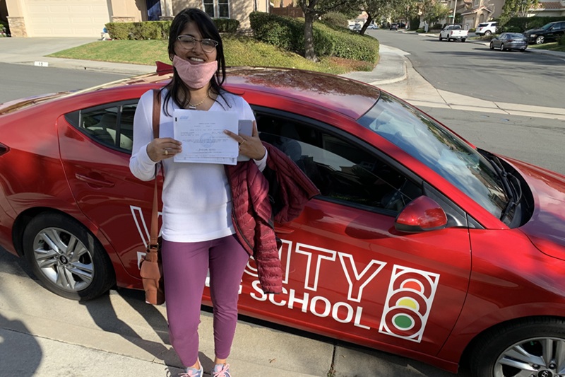 Best Hillview High School Behind the Wheel Training Student Standing Next to a Training Vehicle Parked on a Street