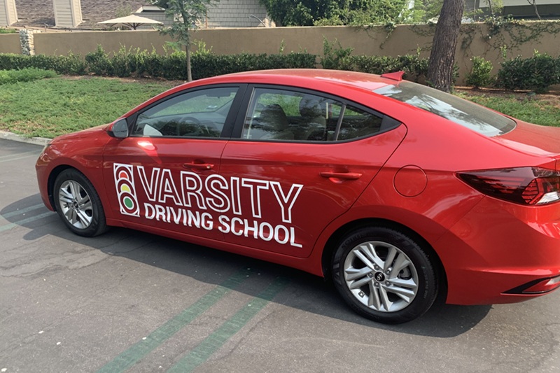 Best John F. Kennedy High School Behind the Wheel Training a Red Training Vehicle Parked in a Parking Lot