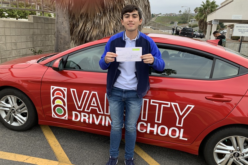Best Century High School Behind the Wheel Training Student Standing Next to a Training Vehicle in a Parking Lot