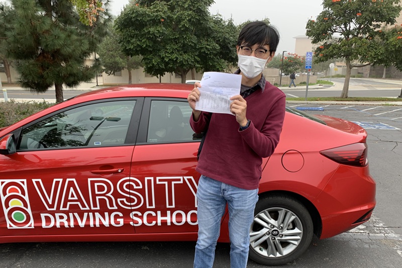Best Century High School Behind the Wheel Training Student Standing Next to a Training Vehicle Outside