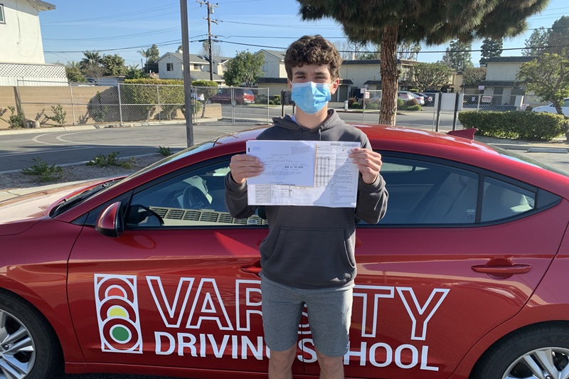 Best Early College High School Driving School Student Standing Next to a Training Vehicle in a Parking Lot